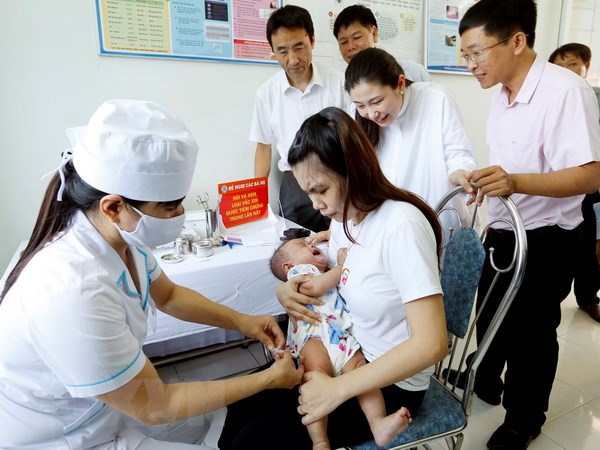 Các đại biểu quốc tế thăm điểm tiêm chủng tại xã Nghĩa Dõng, thành phố Quảng Ngãi. (Ảnh: Dương Ngọc/TTXVN)