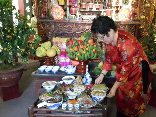 Nghệ nhân Ánh Tuyết với mâm cỗ Tết truyền thống Hà Nội. (Ảnh: Đinh Thị Thuận/TTXVN)