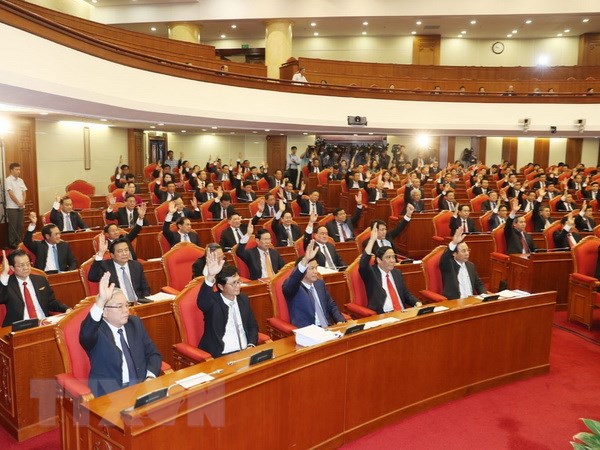 Các đồng chí lãnh đạo Đảng, Nhà nước và các đại biểu biểu quyết thông qua Nghị quyết Hội nghị lần thứ bảy. (Ảnh: Trí Dũng/TTXVN)