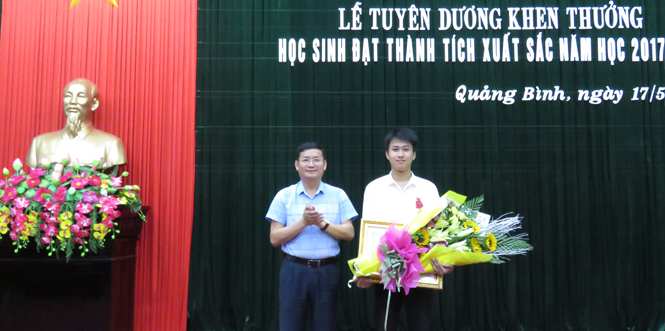 Thừa ủy quyền của Chủ tịch nước, đồng chí Trần Tiến Dũng, Tỉnh ủy viên, Phó Chủ tịch UBND tỉnh trao Huân chương Lao động hạng Ba cho học sinh Nguyễn Thế Quỳnh.