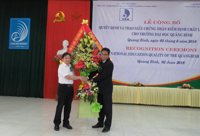 Đồng chí Nguyễn Tiến Hoàng, Tỉnh ủy viên, Phó Chủ tịch UBND tỉnh trao tặng lẵng hoa chúc mừng thầy và trò Trường ĐHQB.