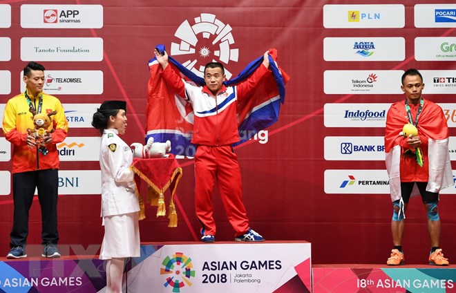 Vận động viên Việt Nam Thạch Kim Tuấn (trái) giành huy chương bạc, Om Yun Chol (giữa) của Triều Tiên giành huy chương vàng và Surahmat Bin Suwoto Wijoyo của Indonesia giành huy chương đồng nội dung cử tạ hạng 56kg. (Nguồn: AFP/ TTXVN)