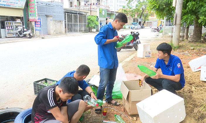 Đoàn viên thanh niên Câu lạc bộ thanh niên thị xã Ba Đồn tận dụng những lốp xe ô tô cũ, vỏ chai nhựa để trồng hoa.