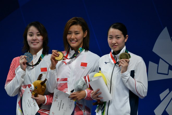 Lưu Sương (giữa) nhận huy chương vàng và phá kỷ lục thế giới 50m bơi ngửa nữ. (Nguồn: Antara)