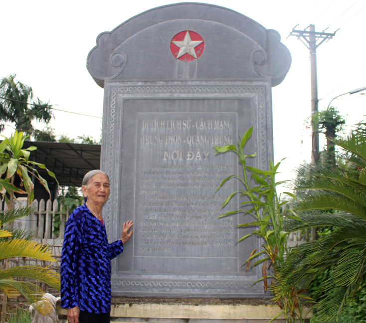 Bà Phạm Thị Liên, em dâu của Trung tướng Đồng Sỹ Nguyên bên bia di tích nơi thành lập Chi bộ Bình.