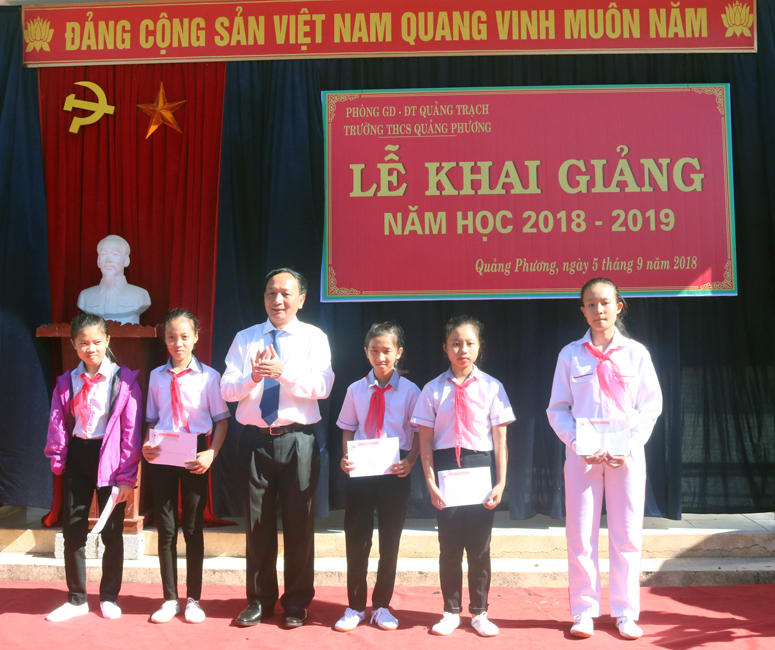 Đồng chí Trần Hải Châu, Ủy viên Ban Thường vụ, Trưởng ban Nội chính Tỉnh ủy trao học bổng cho các học sinh nghèo vượt khó ở Trường THCS Quảng Phương.