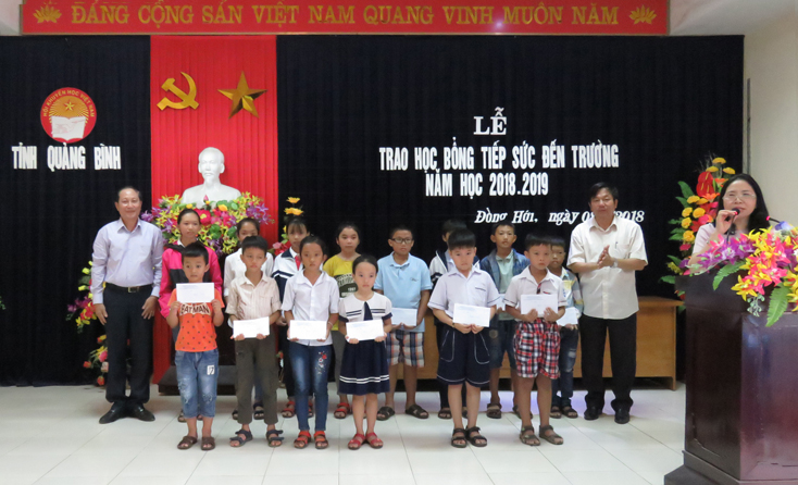 Đại diện lãnh đạo Hội Khuyến học tỉnh, Sở Giáo dục - Đào tạo trao học bổng “Tiếp sức đến trường” các em học sinh huyện Quảng Ninh.
