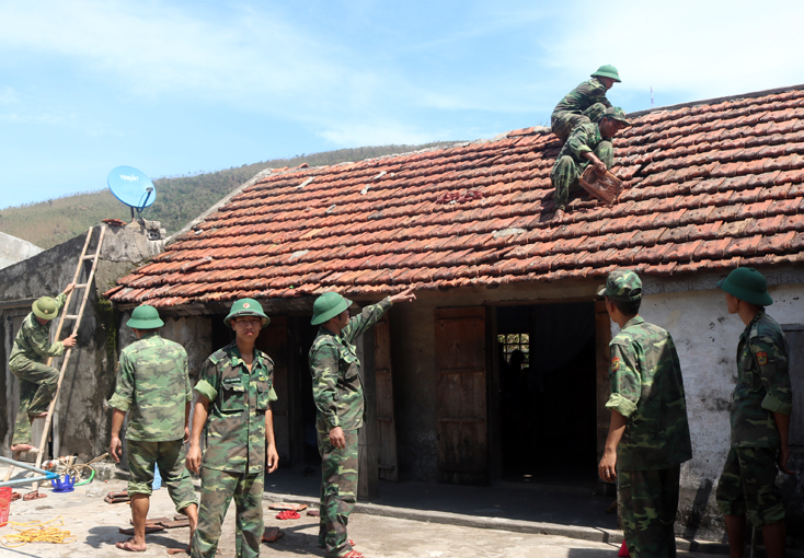 Cán bộ, chiến sĩ BĐBP tỉnh giúp người dân Quảng Trạch lợp lại nhà bị tốc mái do bão.    
