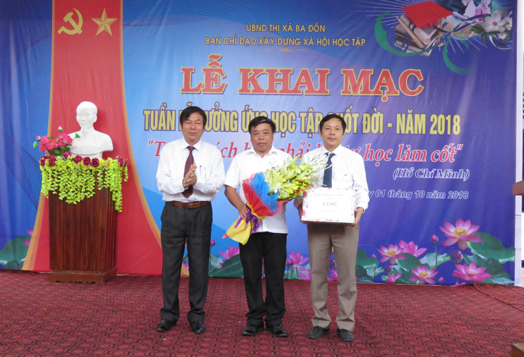 Đại diện Ban Chỉ đạo xây dựng XHHT tỉnh tặng hoa chúc mừng thị xã Ba Đồn tổ chức thành công khai mạc Tuần lễ hưởng ứng học tập suốt đời năm 2018 cấp tỉnh.