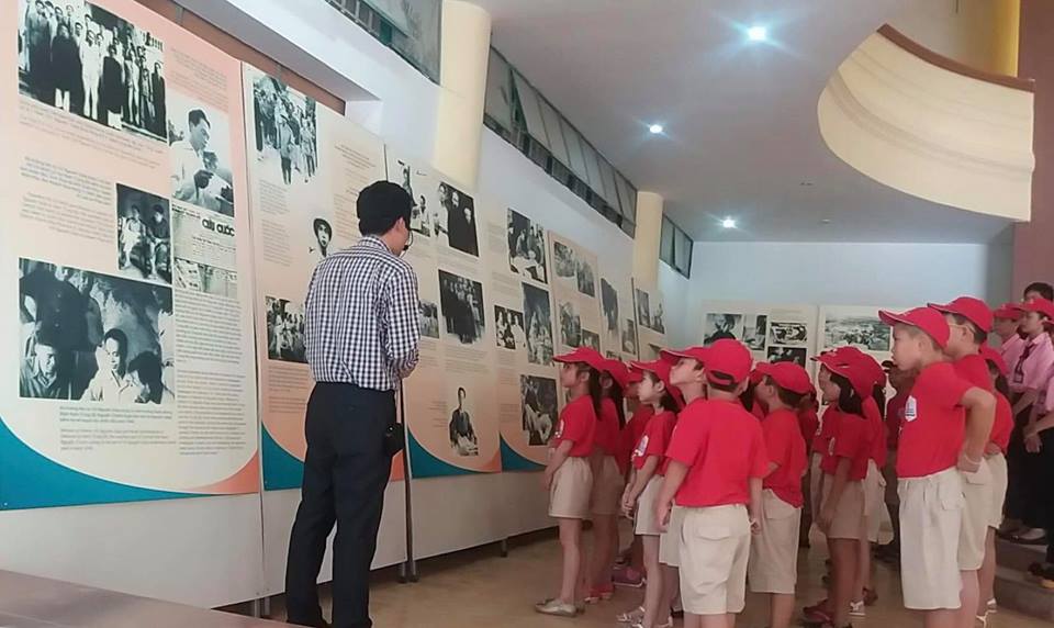 Hướng dẫn viên Bảo tàng Tổng hợp tỉnh giới thiệu với các em học sinh thăm quan triển lãm.