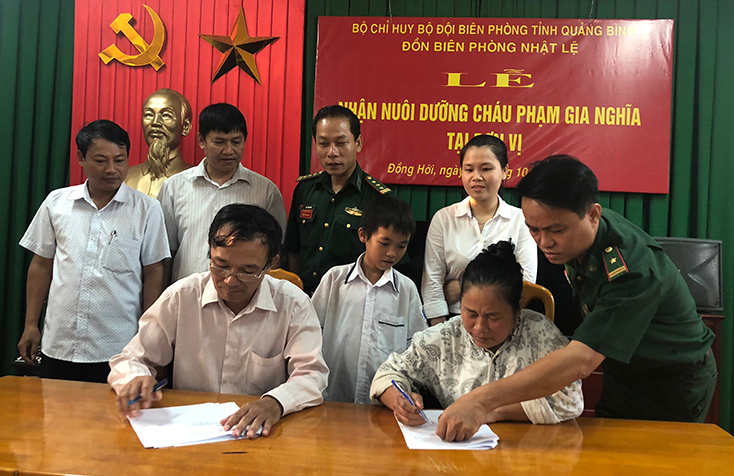 Lễ ký kết nhận nuôi dưỡng em Phạm Gia Nghĩa diễn ra trước sự chứng kiến của lãnh đạo địa phương, nhà trường cùng gia đình. 
