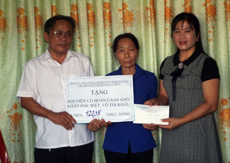 Đại diện Hội CGC, Phòng GD-ĐT huyện Lệ Thủy trao tiền hỗ trợ cho cô Khấu