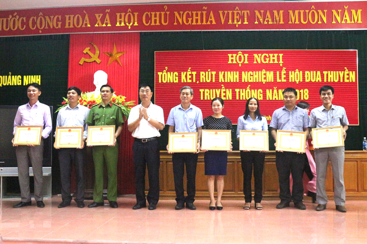 Đồng chí Lê Ngọc Huân, Phó Chủ tịch UBND huyện Quảng Ninh trao giáy khen cho các tập thể, cá nhân có nhiều đóng góp vào thành công của lễ hội đua thuyền.