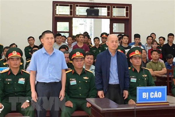 Bị cáo Đinh Ngọc Hệ (đứng, phải) và bị cáo Trần Văn Lâm nghe Hội đồng xét xử đọc bản tuyên án. (Ảnh: TTXVN)
