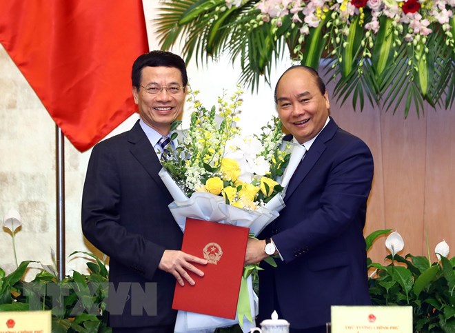 Thủ tướng Nguyễn Xuân Phúc trao Quyết định bổ nhiệm và tặng hoa cho ông Nguyễn Mạnh Hùng giữ chức Bộ trưởng Bộ Thông tin và Truyền thông nhiệm kỳ 2016-2021. (Ảnh: Thống Nhất/TTXVN)