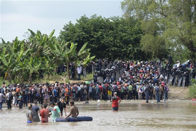 Người di cư băng qua sông Suchiate từ Ciudad Tecun Uman (Guatemala) để tới Ciudad Hidalgo (Mexico) trong hành trình đến Mỹ, ngày 29-10-2018. (Ảnh: AFP/TTXVN)