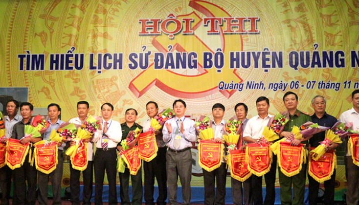 Các đồng chí lãnh đạo huyện Quảng Ninh trao cờ lưu niệm cho các đội dự thi.