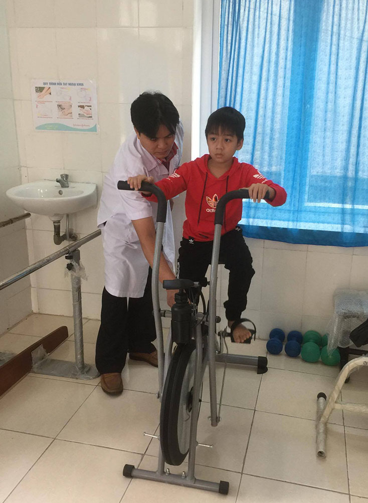 TYT xã Cảnh Dương (Quảng Trạch) đang thực hiện phục hồi chức năng cho trẻ khuyết tật. 