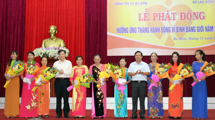 Đồng chí Nguyễn Tiến Hoàng, Phó Chủ tịch UBND tỉnh và đồng chí Phạm Duy Quang, Phó Bí thư Thường trực Thị ủy Ba Đồn trao thưởng cho các phụ nữ là điển hình phát triển kinh tế vươn lên làm giàu.