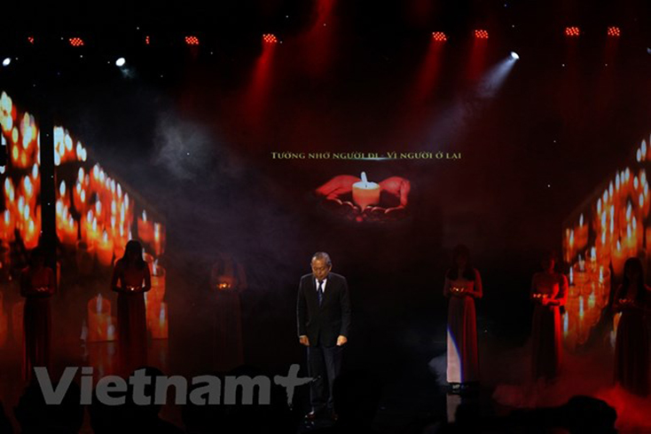 Phó Thủ tướng Chính phủ Trương Hòa Bình cùng các đại biểu dành một phút mặc niệm cho nạn nhân tử vong do tai nạn giao thông. (Ảnh: Việt Hùng/Vietnam+)