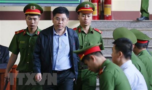 Lực lượng chức năng đưa bị cáo Nguyễn Văn Dương, nguyên Chủ tịch Hội đồng quản trị Công ty TNHH Đầu tư phát triển an ninh công nghệ cao (CNC) vào tòa. (Ảnh: Trung Kiên/TTXVN)