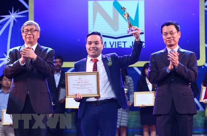 Bộ trưởng Bộ Thông tin và Truyền thông Nguyễn Mạnh Hùng (bên phải) và giáo sư, viện sỹ Đặng Vũ Minh trao giải cho các tác giả có sản phẩm đạt giải tại hạng mục Ứng dụng công nghệ số xuất sắc. (Ảnh: Minh Quyết/TTXVN)