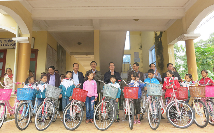 Các đại biểu trao xe đạp cho học sinh nghèo vượt khó trên địa bàn huyện Quảng Ninh.