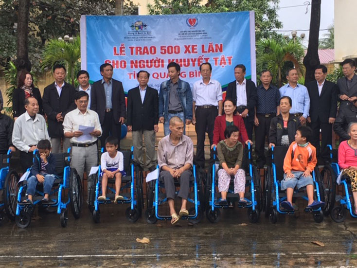 Đại diện lãnh đạo Tổ chức “Trả lại tuổi thơ” và Hội bảo trợ NTT và TMC trao tặng xe lăn cho người khuyết tật.