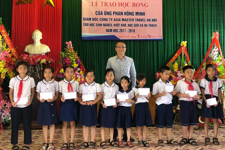 Ông Phan Hồng Minh, Giám đốc Công ty TNHH đầu tư và du lịch lữ hành Asia Master trao quà cho học sinh xã Hạ Trạch, huyện Bố Trạch.