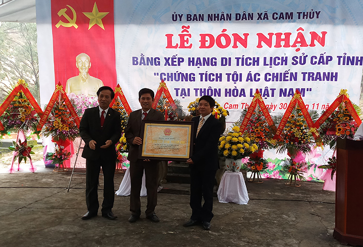 Đại diện lãnh đạo Sở Văn hóa và Thể thao trao bằng xếp hạng Di tích lịch sử cấp tỉnh Chứng tích tội ác chiến tranh tại thôn Hòa Luật Nam, xã Cam Thủy. 