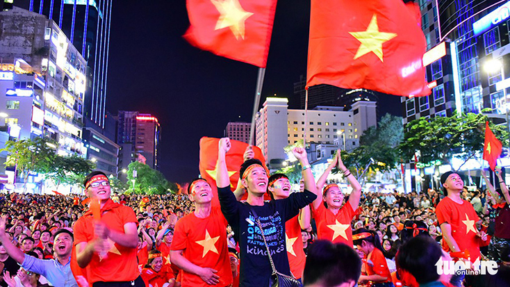 Khoảnh khắc ăn mừng của cổ động viên tại phố đi bộ Nguyễn Huệ (TP.HCM) vui và trật tự khi đội tuyển Việt Nam thắng Philippines trong trận bán kết lượt đi hôm 2-12 - Ảnh: HỮU THUẬN