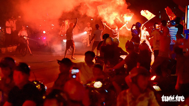 Cổ động viên đốt pháo sáng ăn mừng chiến thắng của đội tuyển Việt Nam trên đường Hàm Nghi, Q.1, TP.HCM tối 2-12 - Ảnh: QUANG ĐỊNH