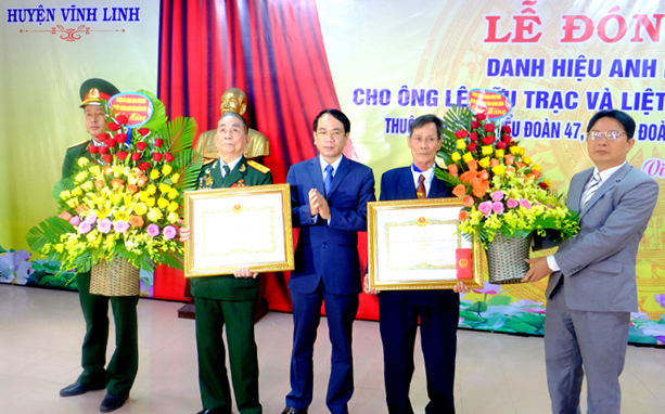 Lãnh đạo huyện Quảng Ninh tặng hoa chúc mừng Anh hùng LLVTND Lê Hữu Trạc.
