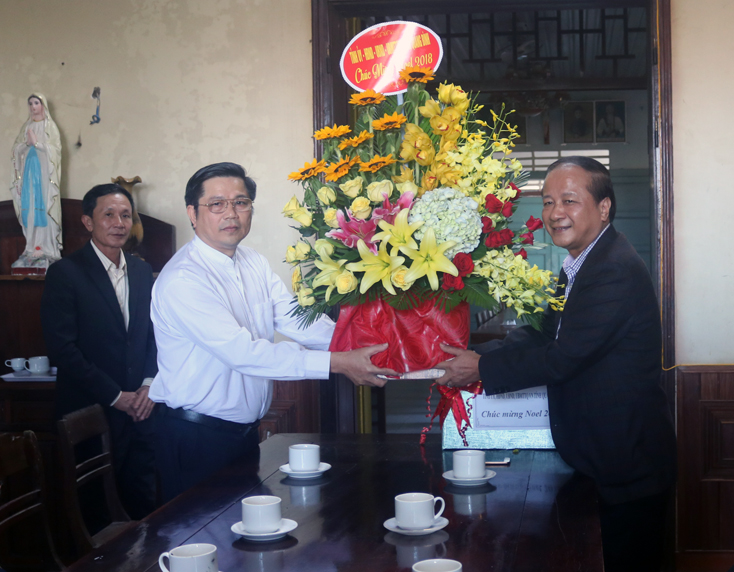 Đồng chí Trần Văn Tuân, Chủ tịch UBMTTQVN tỉnh tặng hoa, quà và chúc mừng Giáng sinh linh mục Lê Nam Cao, quản hạt và quản xứ Hướng Phương.