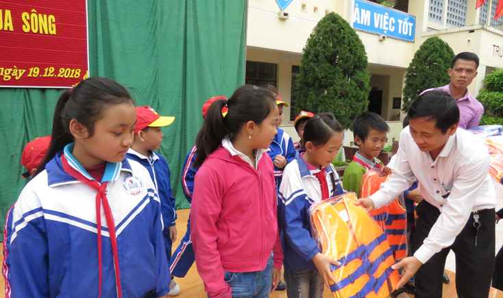 Đại diện Sở Giáo dục-Đào tạo trao áo pháo cho các em học sinh ở thôn Hà Kiên.