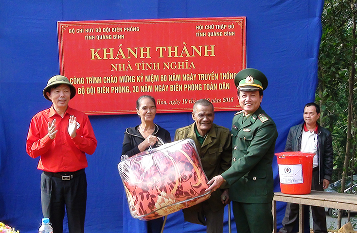 Thượng tá Đinh Xuân Hùng và Ông Cao Quang Cảnh tặng quà cho gia đình ông Hồ Nôn