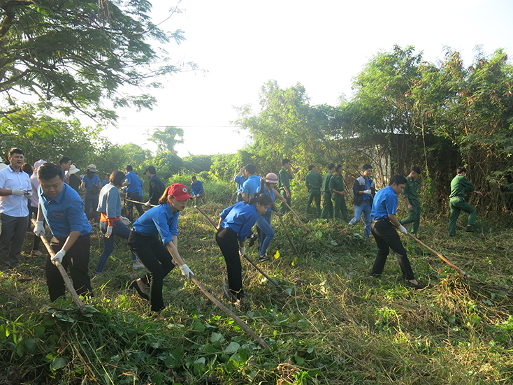 Các đoàn viên Đoàn Khối các cơ qua tỉnh đang dọn vệ sinh trước bia di tích lịch sử Nhà lao Đồng Hới