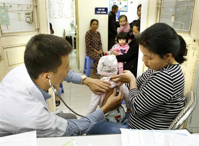 Khám cho trẻ trước khi tiêm chủng. (Ảnh: TTXVN/Vietnam+)