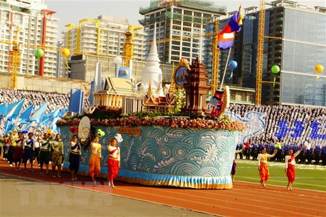 Đoàn diễu hành biểu tượng cho các tỉnh thành, các ngành nghề, lĩnh vực và các lực lượng diễu hành qua lễ đài. (Ảnh: Nhóm P/v TTXVN tại Campuchia)
