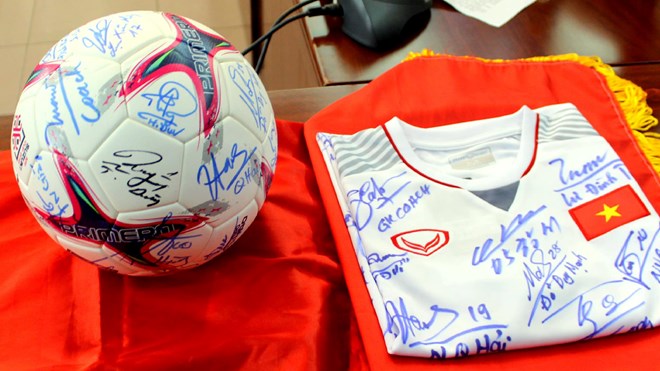 Trái bóng và chiếc áo có chữ ký của các cầu thủ đội tuyển bóng đá nam Quốc gia khi đoạt ngôi vô địch AFF Cup 2018. (Nguồn: Hội Chữ thập Đỏ Việt Nam)