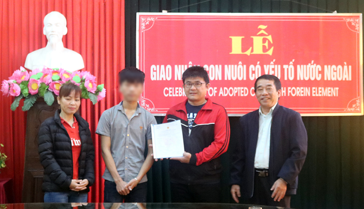 Ông Trần Văn Lê, Phó Giám đốc Sở Tư pháp trao quyết định cho trẻ em Việt Nam làm con nuôi.