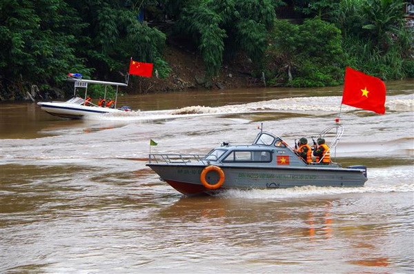 Lực lượng biên phòng hai bên phối hợp tổ chức tuần tra trên sông. (Ảnh: Quốc Khánh/TTXVN)