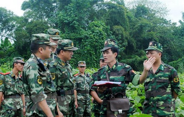 Bộ đội Biên phòng Lào Cai và lực lượng Trạm Kiểm soát Công an Biên phòng Hà Khẩu (Trung Quốc) phối hợp tuần tra biên giới. (Ảnh: Quốc Khánh/TTXVN)