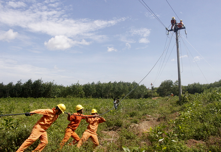 Công nhân Điện lực Đồng Hới thi công nâng cấp hệ thống lưới điện tại thị trấn Nông trường Việt Trung (Bố Trạch).
