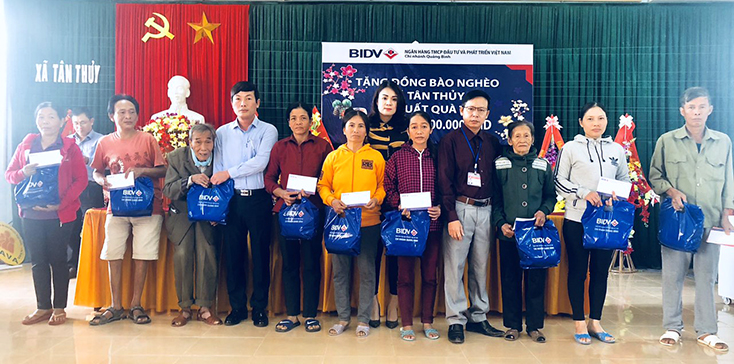 Đại diện lãnh đạo BIDV Quảng Bình tặng quà Tết cho các hộ nghèo tại xã Tân Thủy, huyện Lệ Thủy.