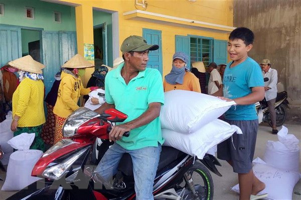Người dân ở xã Phước Nam, huyện Thuận Nam, Ninh Thuận chở gạo cấp phát cứu đói do Chính phủ hỗ trợ. (Ảnh: Công Thử/TTXVN)