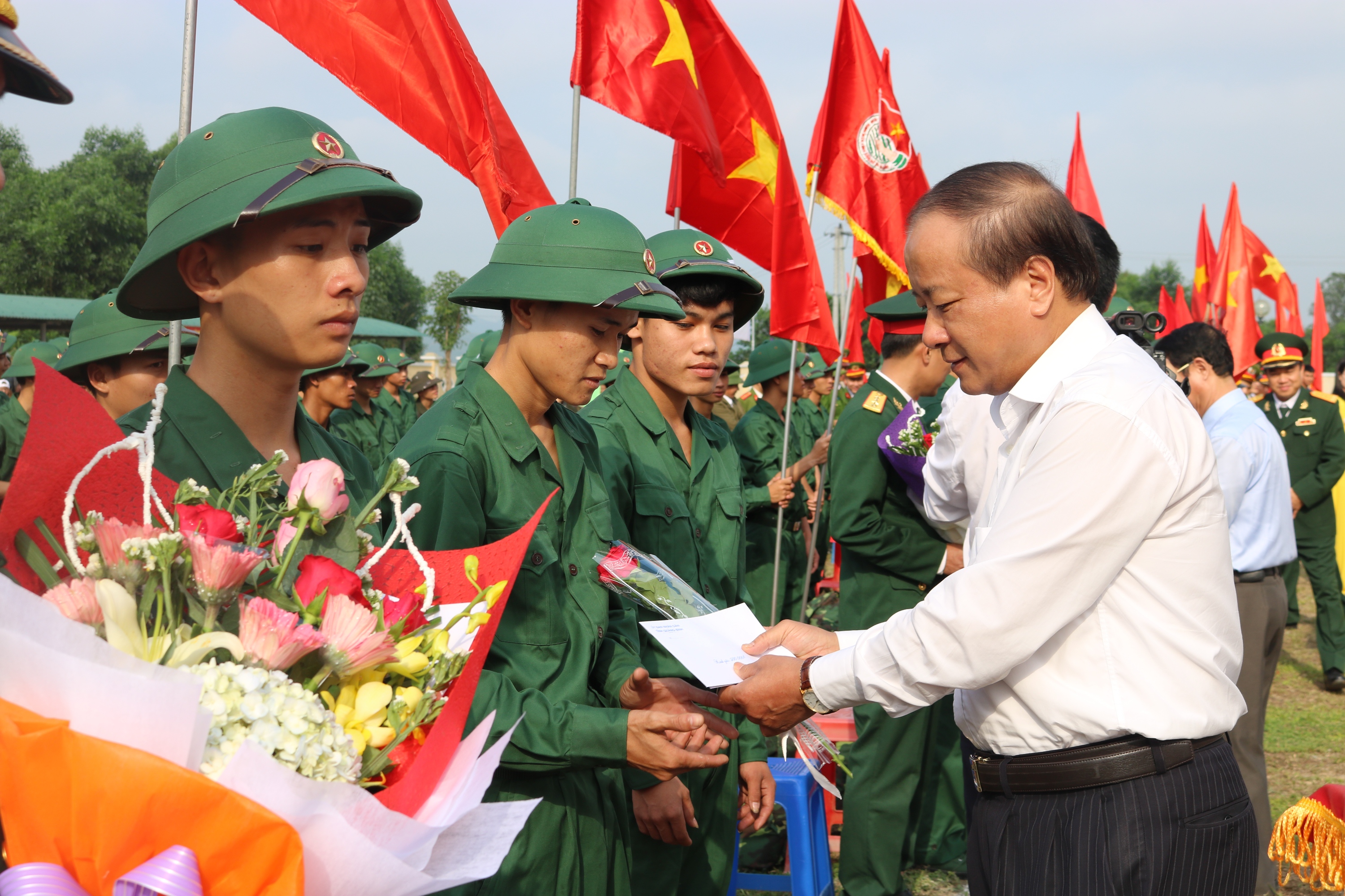  Đồng chí Trần Văn Tuân, Ủy viên Ban Thường vụ Tỉnh ủy, Chủ tịch UBMTTQVN tỉnh tặng hoa động viên các tân binh lên đường nhập ngũ