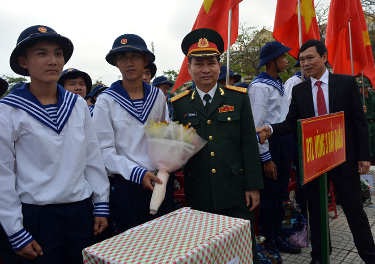 Đại tá Nguyễn Văn Man, Ủy viên Ban Thường vụ Tỉnh ủy, Chỉ huy trưởng Bộ chỉ huy Quân sự tỉnh và lãnh đạo huyện Bố Trạch tặng hoa, động viên các tân binh lên đường làm nhiệm vụ.