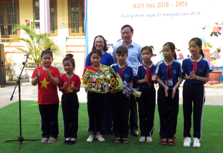 Đồng chí Giám đốc Sở GD-ĐT Đinh Quý Nhân tặng hoa chúc mừng giáo viên và học sinh Trường tiểu học Cam Thủy (Lệ Thủy).