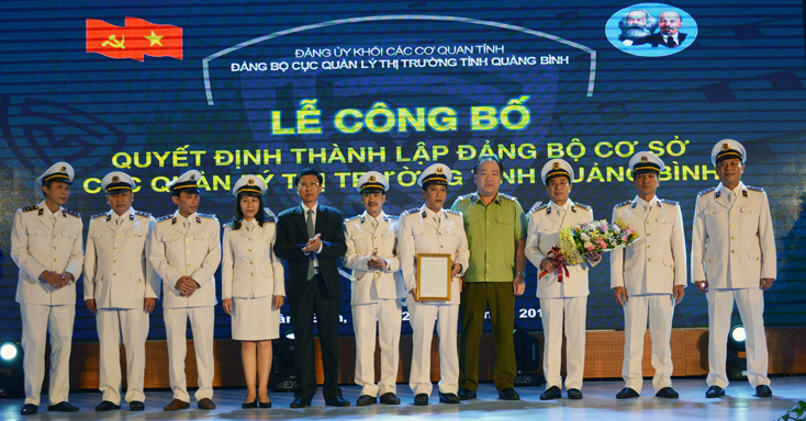Bí thư Đảng ủy Khối Các cơ quan tỉnh Hoàng Minh Tiến và lãnh đạo Tổng Cục QLTT trao Quyết định thành lập Đảng bộ cơ sở và tặng hoa chúc mừng Ban Chấp hành Đảng bộ Cục QLTT Quảng Bình.